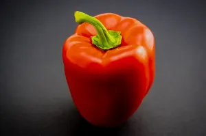Fresh green, red and yellow peppers with water drops isolated on white background.